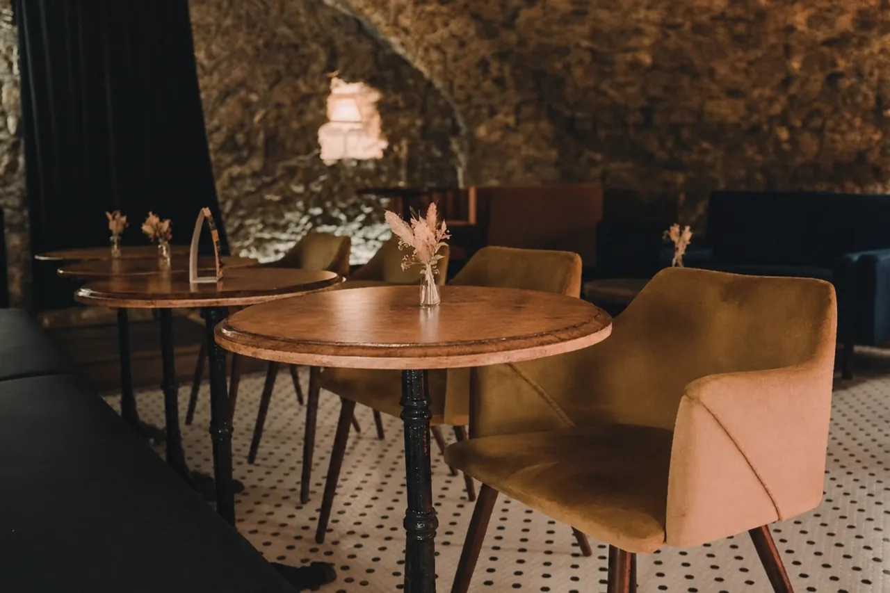 Tables and banquette seating beneath the stone vault at Les Folies d’Edmonde